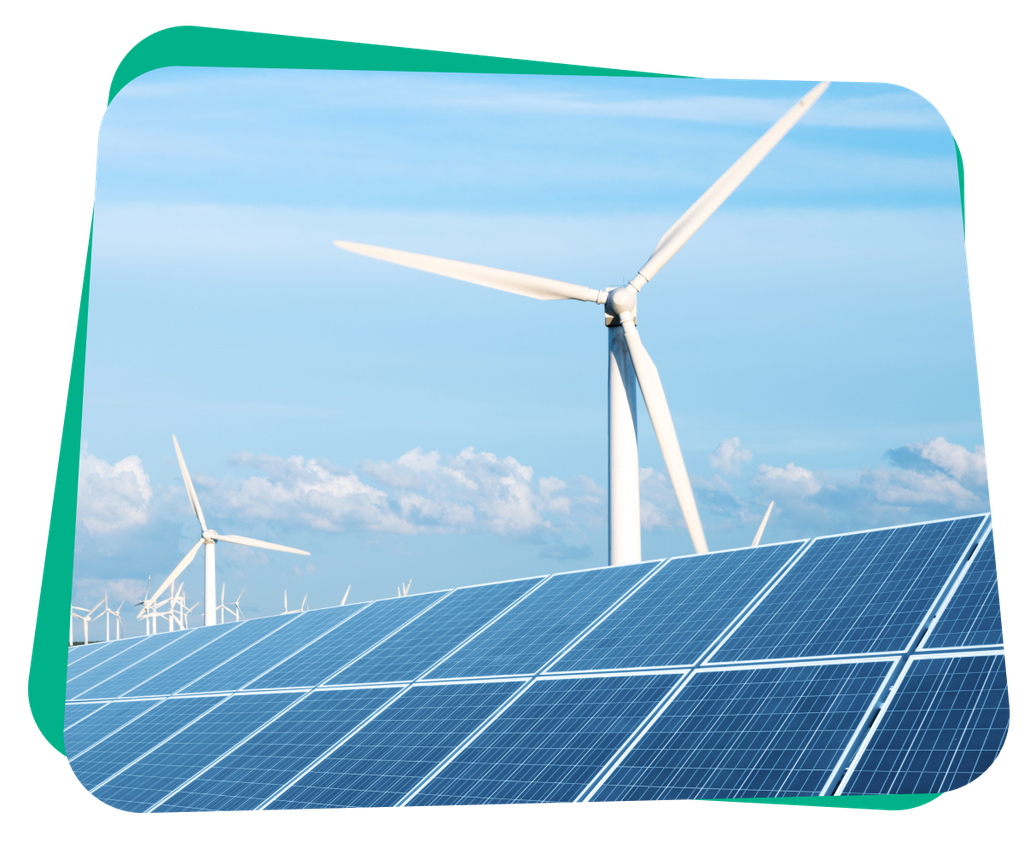 A wind farm with several turbines stands behind an array of solar panels under a partly cloudy sky.
